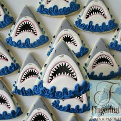 decorated cookies with blue icing and white frosting are arranged in the shape of shark's teeth