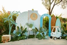 an outdoor display with surfboards and palm trees in the foreground, along with other decorations