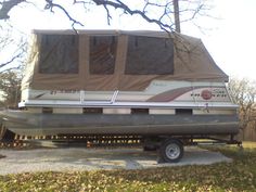 a trailer with a boat on it parked in the grass