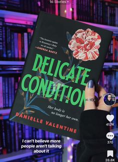 a person holding up a book in front of bookshelves