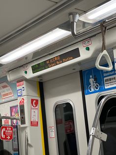 the inside of a subway car with signs and lights on it's doors,