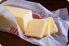 four pieces of cheese sitting on top of a piece of wax paper next to each other