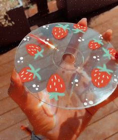 a person holding a glass plate with strawberries on it