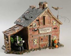 a figurine of two people standing in front of a building with cats on the roof