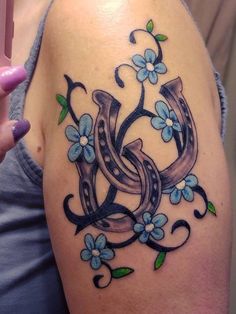 a woman's arm with blue flowers on it and the letter e painted on it