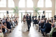 a bride and groom are walking down the aisle