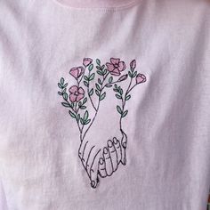 embroidered t - shirt with hand and flowers on it