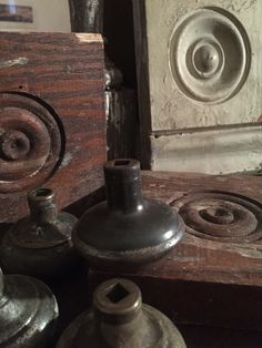 an assortment of old metal objects sitting on top of a wooden table next to a door