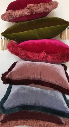 five pillows stacked on top of each other with tassels hanging from the back