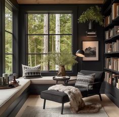 a living room filled with lots of books and furniture next to a window covered in plants