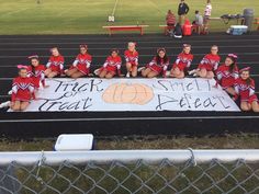 the cheerleaders are posing for a photo on the sidelines in their red uniforms