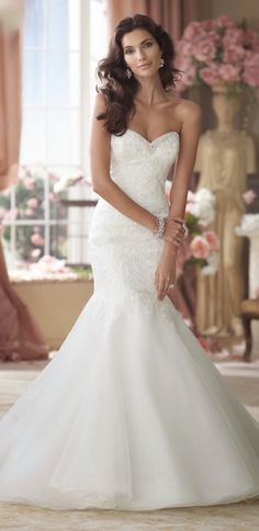 a woman in a wedding dress posing for the camera