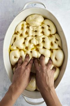 two hands reaching for doughnuts in a pot