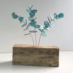 a wooden block with some metal flowers on it