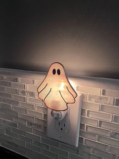 a light that is on the side of a wall with a ghost face drawn on it