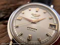 an old watch sitting on top of a wooden table