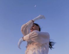 a woman in white dress flying through the air