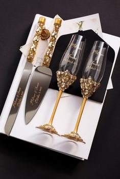 two champagne flutes and a knife are sitting in a box next to a bottle opener