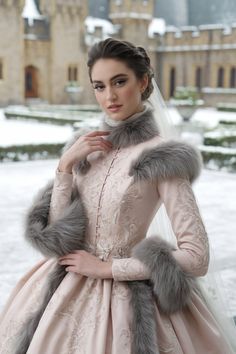 a woman in a pink dress and fur stoler standing on the snow covered ground