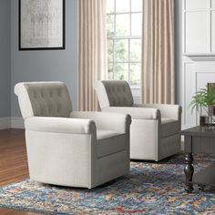 a living room with two chairs and a rug