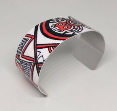 "This lightweight, adjustable aluminum cuff features artwork by Cherokee Nation artist, MaryBeth Timothy. The title of this image is \"SouthEast Spiders\". Although the art is done in a contemporary style, the designs on this cuff are actually a variety of ancient mound symbols found in or around the native burial mounds (Moundville, AL; Spiro, Ok; Etowah, GA; etc.). This cuff features the spider motif. The cuffs are easily squeezed and pulled apart to adjust to most adult sized wrists. Dimensio Adjustable Artistic Cuff Bracelet, Adjustable Wearable Art Cuff Bracelet Gift, Adjustable White Cuff Bangle Bracelet, White Adjustable Bangle Cuff Bracelet, Hand Painted Adjustable Cuff Bracelet As Gift, Artistic White Adjustable Jewelry, Southeast Native Americans, Bookmark Printing, Metal Bookmarks