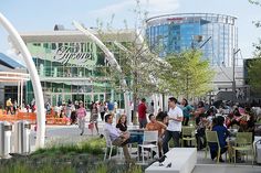 many people are sitting at tables outside in the city