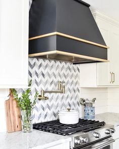 a stove top oven sitting inside of a kitchen next to a wall mounted range hood