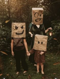 two children wearing paper bags with faces on them, one holding the other's hand