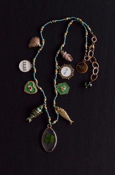 CHARM NECKLACE ON GREEN CORD Nine charms are hand knotted with small gold beads on green cord. DETAILS: *Charms: NINE Gold plated charms. Shell, 11:11, Heart, Fish, Clover, Fish, Bee, Love, Shell. *Cord: Hand knotted on green cord. *Clasp: Lobster. *Extension chain. *Select your size from the drop down menu. PROCESSING TIME: *14  days.  All the jewelry on my site is made to order by me with love and care. ❤️ GIFT WRAP OPTION: *You can select gift wrap option. Your gift will arrive in a branded A Green Charms Jewelry For Good Luck, Green Good Luck Charms Necklace, Green Hand-strung Amulet Jewelry, Green Vintage Charm Brass Jewelry, Green Brass Jewelry With Vintage Charm, Vintage Charm Green Brass Necklaces, Green Brass Necklaces With Vintage Charm, Green Brass Necklace With Round Beads, Green Beaded Brass Necklaces