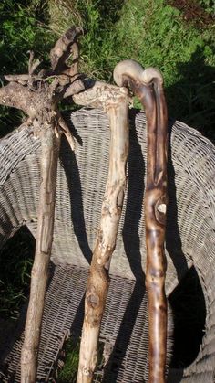 two wooden sticks sitting next to each other on top of a wicker chair in the grass