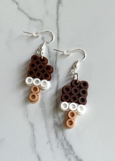 the earrings are made out of legos and have brown, white, and black circles