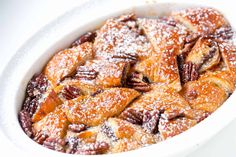 a white bowl filled with dessert covered in powdered sugar