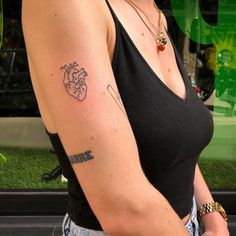 a woman with a heart tattoo on her arm