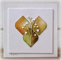 a card with some flowers in it on top of a white surface and the words love written