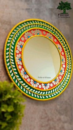 a round mirror hanging on the wall next to a potted plant