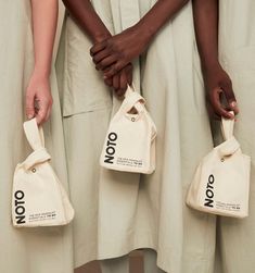 three people holding bags with the word no on them