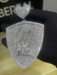 a close up of a person's hand wearing a black glove with a diamond heart on it