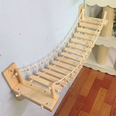 a wooden bed frame sitting on top of a hard wood floor next to a mirror