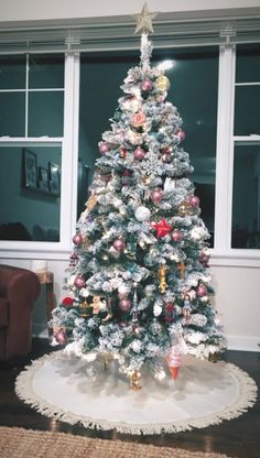 a decorated christmas tree in front of a window