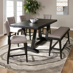 a dining room table and chairs with a rug on the floor