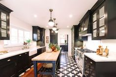 a kitchen with black and white flooring and wooden counter tops, along with an island in the middle