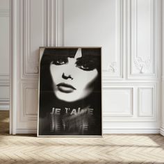 a black and white photo of a woman's face in front of a wall