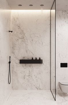 a modern bathroom with marble walls and flooring, along with a black shower head