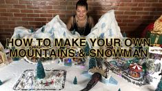 a woman sitting in front of a table with snow covered mountains and trees on it