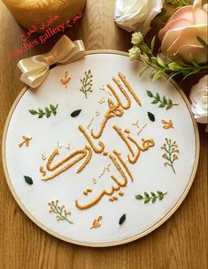 the embroidery pattern is written in arabic on a white cloth with flowers and leaves around it