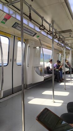 people are sitting on the inside of a subway car