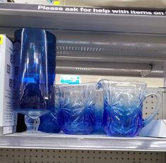 plastic cups and pitchers are sitting on the shelf in a grocery store's display case