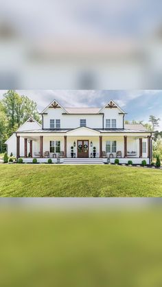 a large white house sitting on top of a lush green field