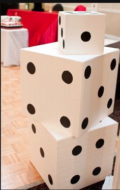 several white and black dices stacked on top of each other in the middle of a room