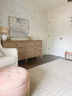 a baby's room with pink furniture and wallpaper